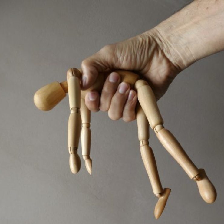 person holding brown wooden mannequin