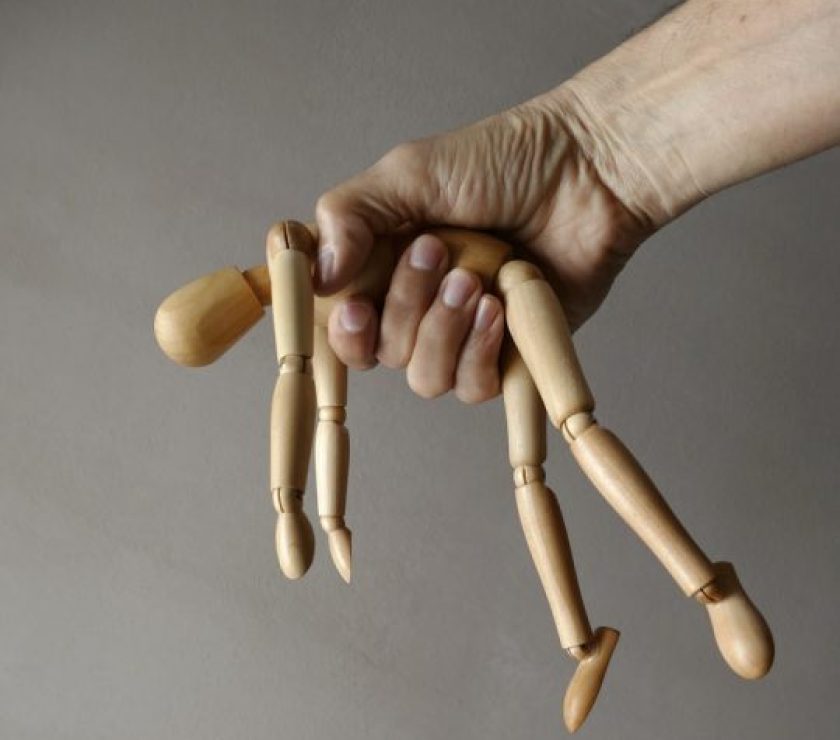 person holding brown wooden mannequin