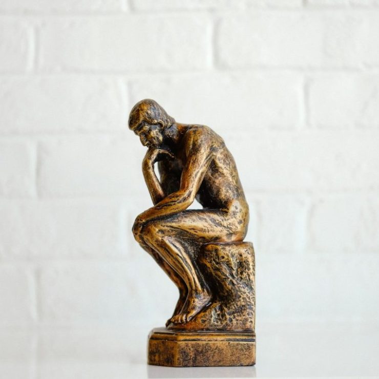 brown concrete statue of man thinking