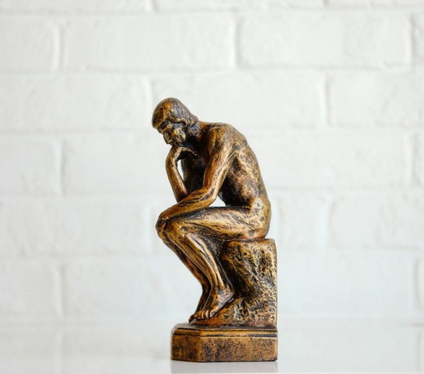 brown concrete statue of man thinking