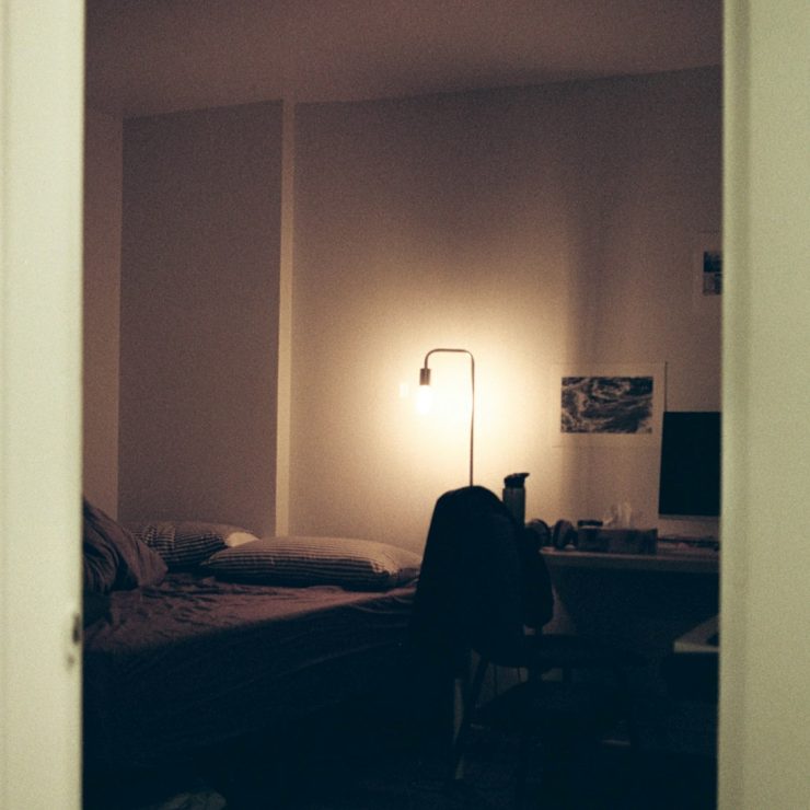 black textile on bed near white wall