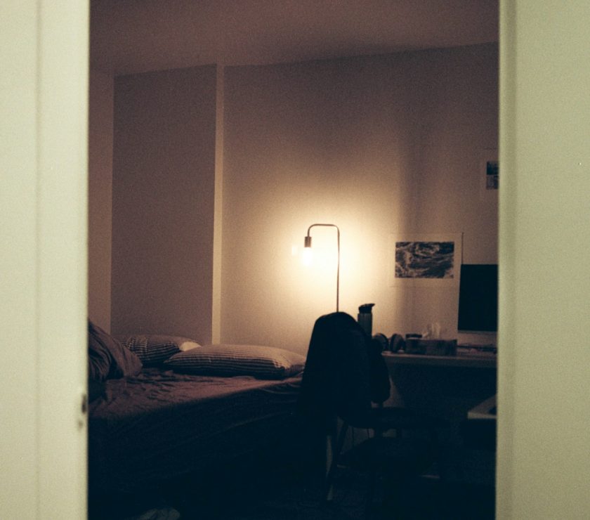 black textile on bed near white wall